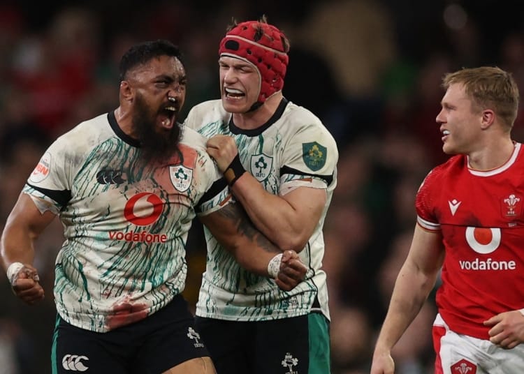 Ireland's flanker Josh Van der Flier (C) and Ireland's Bundee Aki (L) react to winning a penalty during the Six Nations international rugby union match between Wales and Ireland at the Principality Stadium in Cardiff, south Wales, on February 22, 2025. (Photo by Adrian Dennis / AFP) / RESTRICTED TO EDITORIAL USE. USE IN BOOKS SUBJECT TO WELSH RUGBY UNION (WRU) APPROVAL.