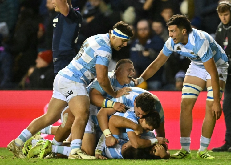 Argentina's Justo Piccardo is crushed by celebrating teammates after scoring a late try during the Autumn Nations Series international rugby union match between Scotland and Argentina at Murrayfield in Edinburgh on November 16, 2025. (Photo by ANDY BUCHANAN / AFP)